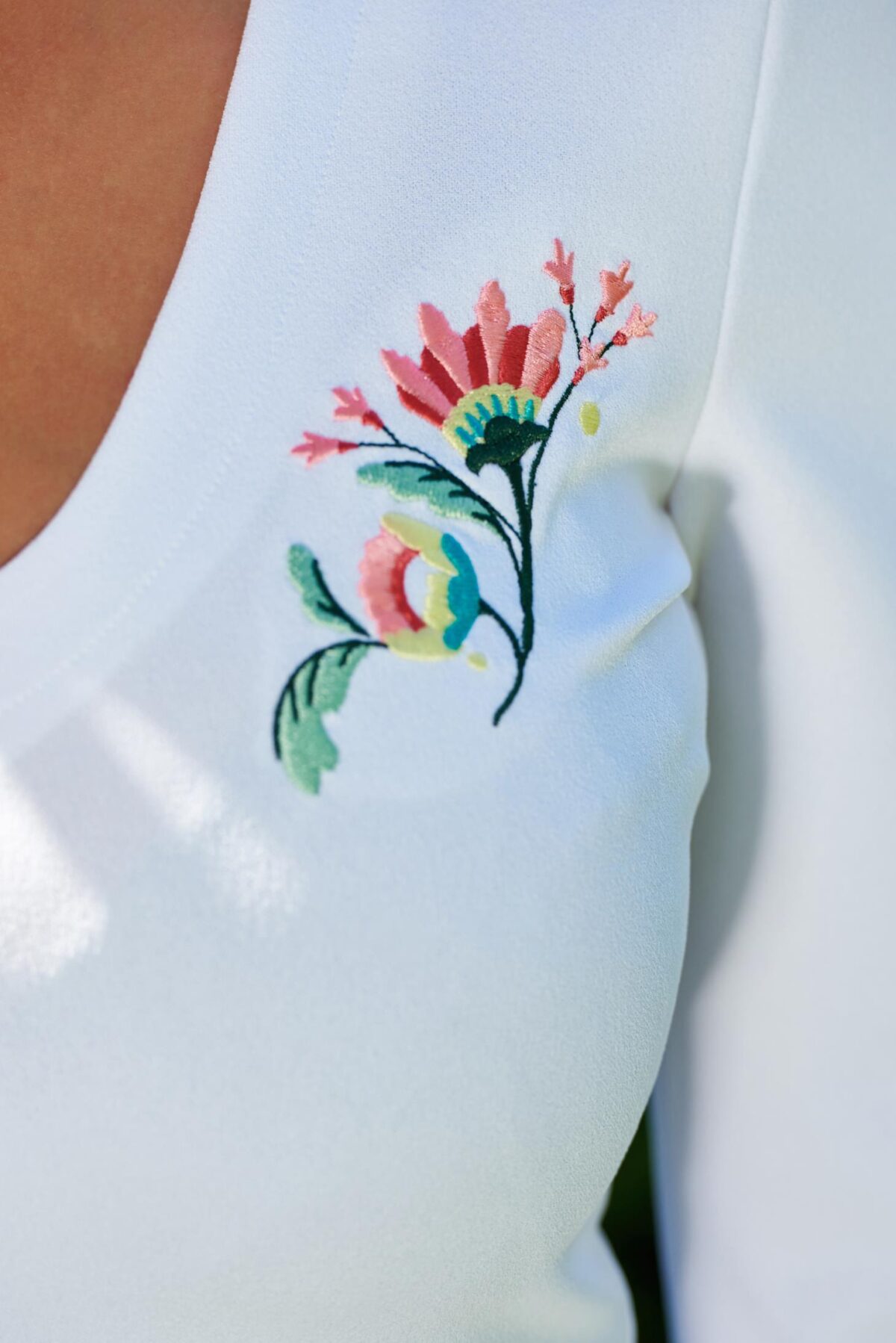 White embroidered women`s blouse with a cleavage and bell sleeves